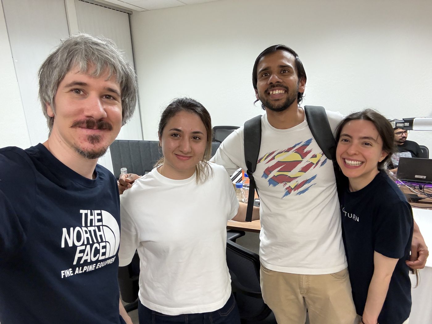 The four members of Team Proxemics standing together, smiling, in an office.